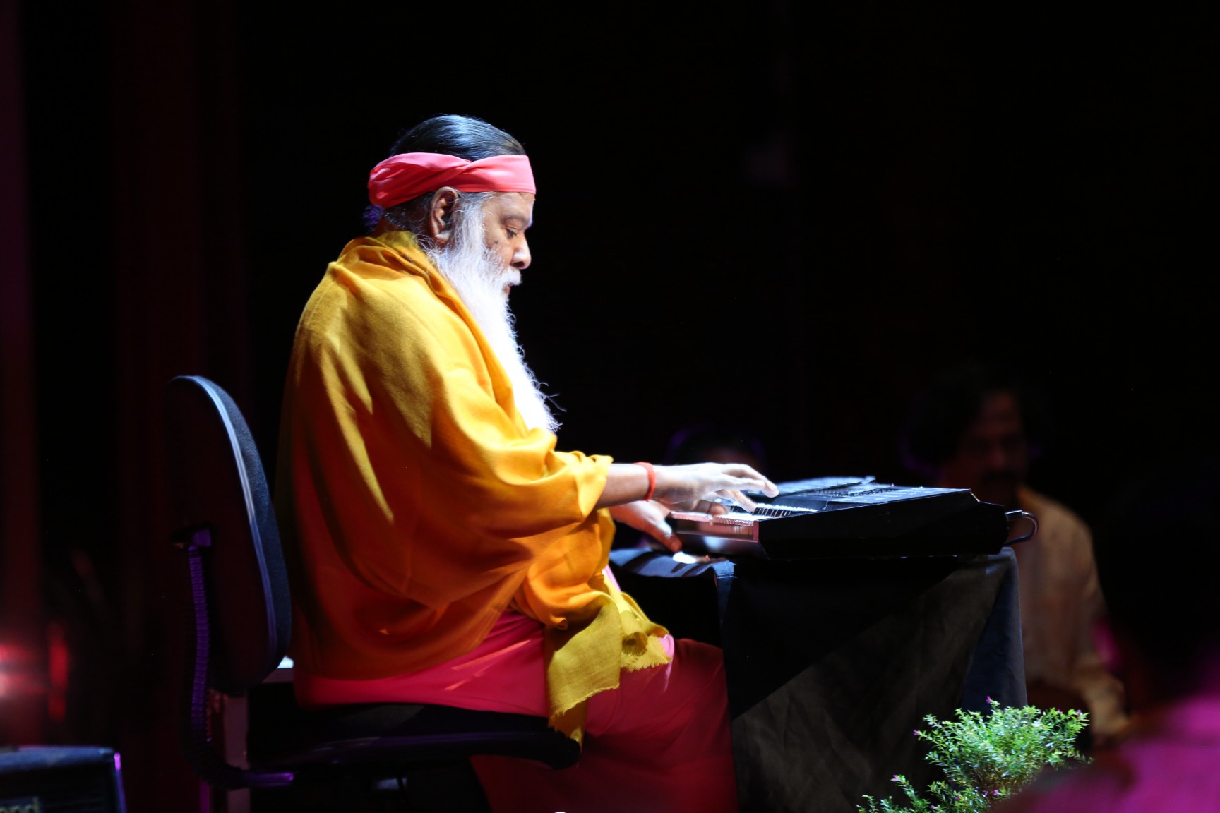Sri Swamiji at keyboard — golden robe